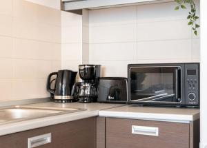 a kitchen counter with a microwave and a sink at Vivando - Bright 1BR - Green View Balcony - Parking in Bucharest