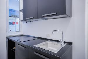 Una encimera de cocina con un fregadero y una ventana. en Napoli Games Apartments by Dimorra, en Nápoles