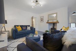 a living room with two blue couches and a fireplace at Unicorn House Hot Tub Near Barnard Castle in Barnard Castle