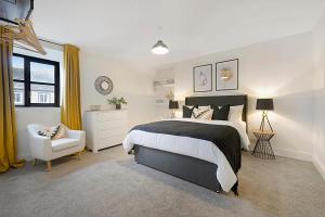 a bedroom with a black and white bed and a chair at Unicorn House Hot Tub Near Barnard Castle in Barnard Castle