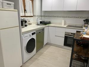 a kitchen with a washing machine and a refrigerator at Casa José Morella in Morella