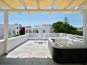 a patio with a tub on the roof of a house at Villa Maria - Naoussa Fishes Blue & Grey Suite in Naousa