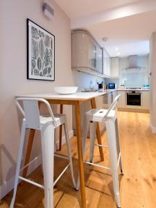 ロンドンにあるMadison Hill - Byrne Garden 3 - One bedroom homeのキッチン(テーブル、白い椅子2脚付)