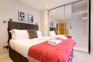 - une chambre avec un grand lit et une couverture rouge dans l'établissement Madison Hill - Byrne Garden 3 - One bedroom home, à Londres