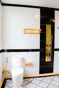 a bathroom with a toilet and a black and white wall at Puok Hotel in Phumĭ Puŏk Chăs