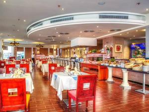 a restaurant with tables and red chairs and a buffet at PORTO MATROUH-GREEN Beach family's only in Marsa Matruh