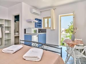 een kamer met een keuken en een tafel met handdoeken bij Villa Maria - Naoussa Squares Blue & Gold Suite in Naousa