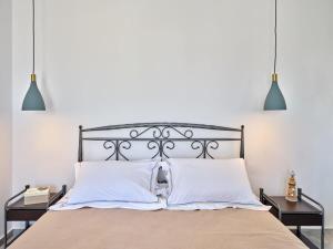 een slaapkamer met een bed met 2 nachtkastjes bij Villa Maria - Naoussa Squares Blue & Gold Suite in Naousa