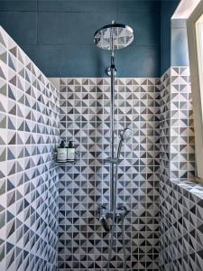 a bathroom with a shower with black and white tiles at Villa Maria - Naoussa Squares Blue & Gold Suite in Naousa