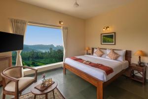 科塔吉里Solitude by Nature Resorts and Stays的一间带大床和大窗户的卧室