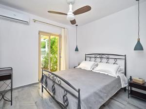 a bedroom with a bed with a ceiling fan at Villa Maria - Naoussa Surfers Bluewave Suite in Naousa