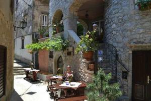 a woman sitting at a table outside of a building at Apartments Villa Dinka in Opatija