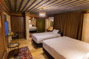 a hotel room with two beds and a chandelier at Uçhisar Premium in Nevsehir