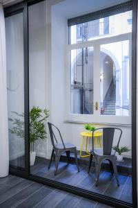 una mesa amarilla y sillas en una habitación con ventana en Napoli Games Apartments by Dimorra, en Nápoles
