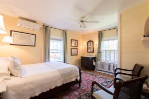 1 dormitorio con 1 cama y 1 silla en Marshall Slocum Inn, en Newport