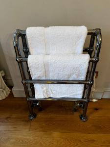 a towel rack with white towels on top of it at The Old Rectory in Kings Lynn