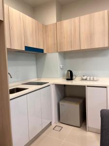 a small kitchen with white cabinets and a sink at D'Shore Kota Kinabalu in Kota Kinabalu