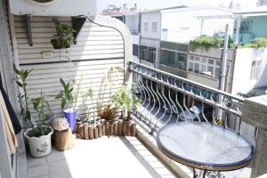 a balcony with a table and potted plants at 巧緣民宿11人包棟 in Hualien City