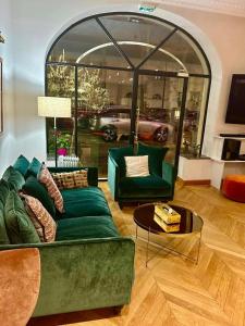 ein Wohnzimmer mit einem grünen Sofa und einem Tisch in der Unterkunft Hôtel Derby Eiffel in Paris