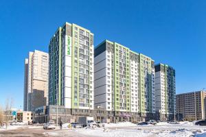 un edificio alto con ventanas verdes en una ciudad en Улучшенные апартаменты в центре города en Promyshlennyy