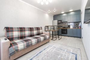 sala de estar con sofá y cocina en Улучшенные апартаменты в центре города en Promyshlennyy