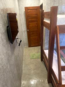 Pokój z łóżkiem piętrowym, telewizorem i drzwiami w obiekcie RL Harbor Inn w mieście El Nido