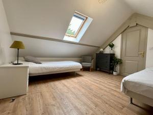 - une chambre mansardée avec 2 lits et une fenêtre dans l'établissement Les Villas de Puys : Luxueuse Villa 7-9Pers, à Dieppe