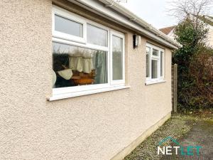 a window of a house with a cat in it at Zephyr Heights in Pembrokeshire