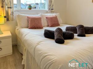 a bed with some pillows on top of it at Zephyr Heights in Pembrokeshire