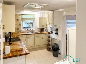 a kitchen with white cabinets and a counter top at Zephyr Heights in Pembrokeshire