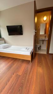 sypialnia z łóżkiem oraz łazienka z umywalką w obiekcie Pokoje na Cyplu w mieście Mrągowo