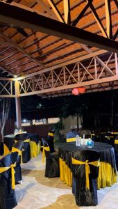 una fila di tavoli con tovaglia gialla e nera di Wild Woods Tiger Resort a Nagpur