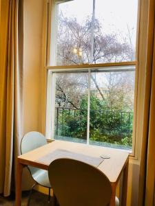 un tavolo e due sedie davanti a una finestra di Central studio flat with parking permit a Bath