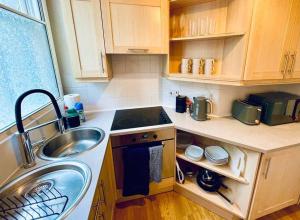 a small kitchen with a sink and a counter top at Central studio flat with parking permit in Bath