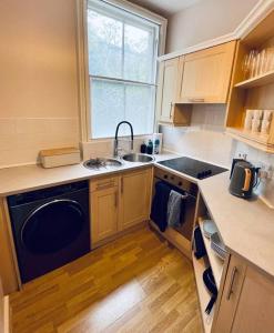 a small kitchen with a sink and a dishwasher at Central studio flat with parking permit in Bath