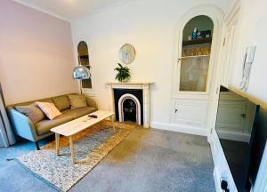 a living room with a couch and a fireplace at Central studio flat with parking permit in Bath