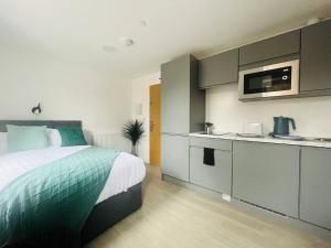una camera con un grande letto e una cucina di Modern Minimalist Studio in Stretford a Manchester