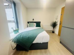 una camera con un letto e un piumone verde e bianco di Modern Minimalist Studio in Stretford a Manchester