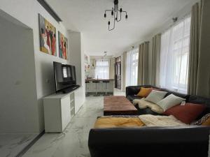 a living room with a couch and a tv at Blumenhaus in Idar-Oberstein