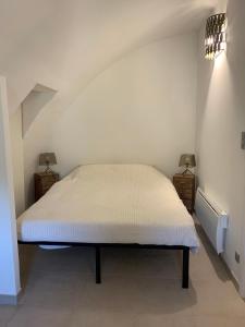 een bed in een kamer met twee lampen aan de muur bij Mas Saint Laurent in Les Salles-du-Gardon