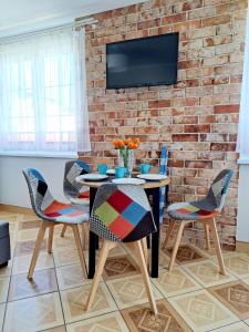 a dining room with a table and chairs and a brick wall at Czarmorza Pokoje Gościnne in Mielno