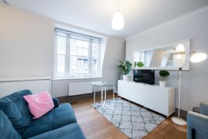 a living room with a couch and a tv at 2Bed Cosy Flat in Vibrant Fitzrovia in London