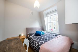 a bedroom with a bed and a table and a window at 2Bed Cosy Flat in Vibrant Fitzrovia in London