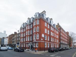 a large red brick building on a city street at 2Bed Cosy Flat in Vibrant Fitzrovia in London