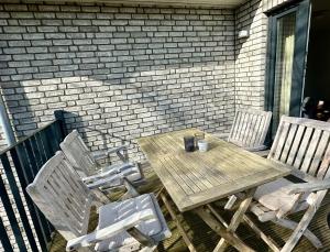 ein Holztisch und zwei Stühle auf einer Terrasse in der Unterkunft 1904 - Am Kurpark in Dahme + 8 Fotos
