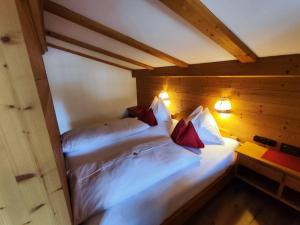two beds in a room with wooden walls at Hotel Gut Kramerhof in Kirchdorf in Tirol