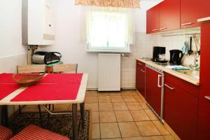 a kitchen with red cabinets and a red table in it at Fewo Urlaubsidyll 1_GUeTH in Ostseebad Karlshagen