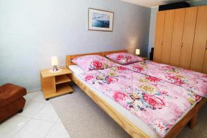 a bedroom with a bed with pink sheets and pillows at Fewo Urlaubsidyll 1_GUeTH in Ostseebad Karlshagen