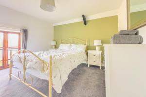 a bedroom with a bed with a white bedspread at Seaside-Dog Friendly-Country Cottage-w log burner in Worle