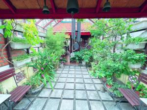 une terrasse avec deux bancs, des arbres et des plantes dans l'établissement May - Maison De Charme 02, à Hanoï